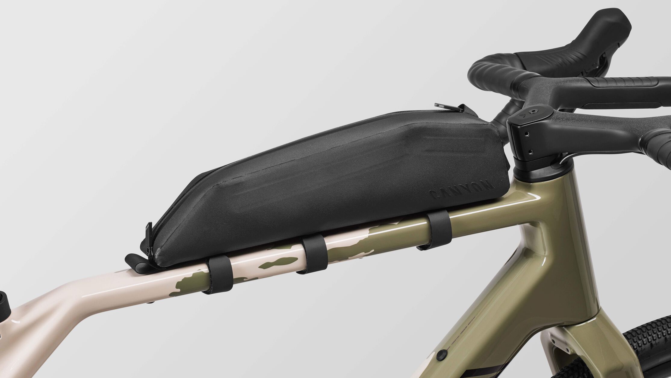 Primer plano de una bicicleta de gravel Canyon GRIZL CF 7 ESC con una bolsa de tubo superior montada, ideal para principiantes para llevar aperitivos, herramientas o accesorios en rutas m&aacute;s largas.