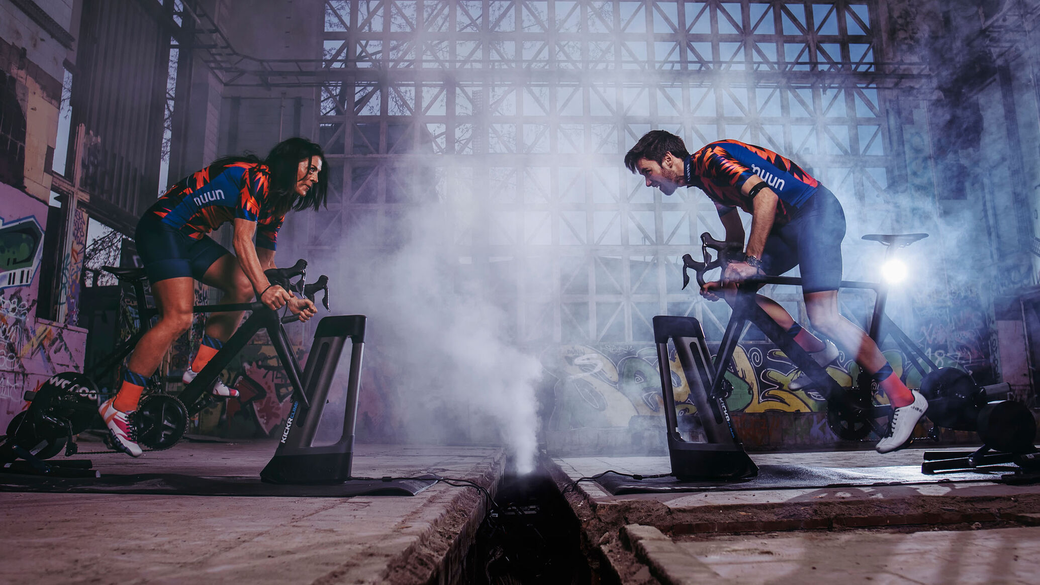 Two riders face each other on their turbo trainers in a battle on Zwift.