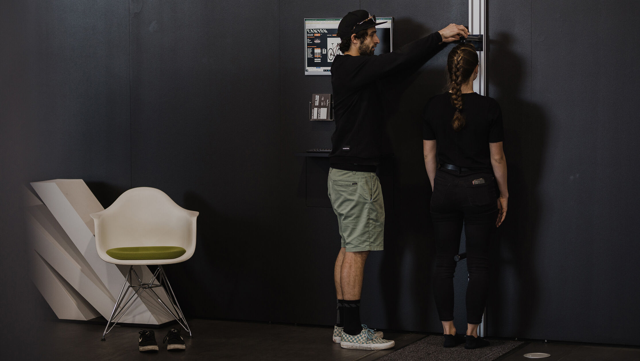 A bike fitter measures a rider's height to determine the correct road bike size, a crucial step for achieving optimal fit and performance.